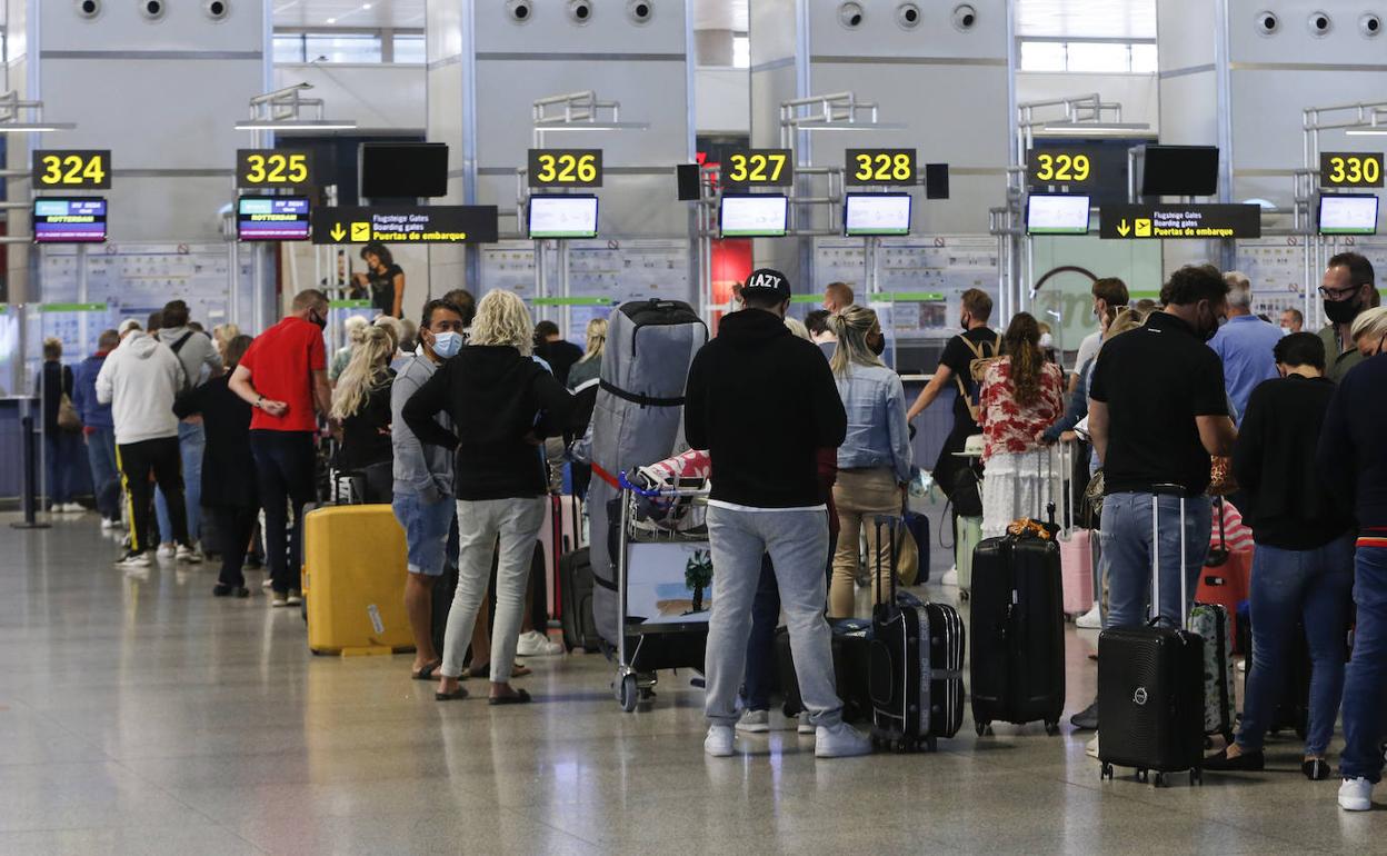 Turistas hacen cola ante los mostradores de facturación del aeropuerto de Málaga. 