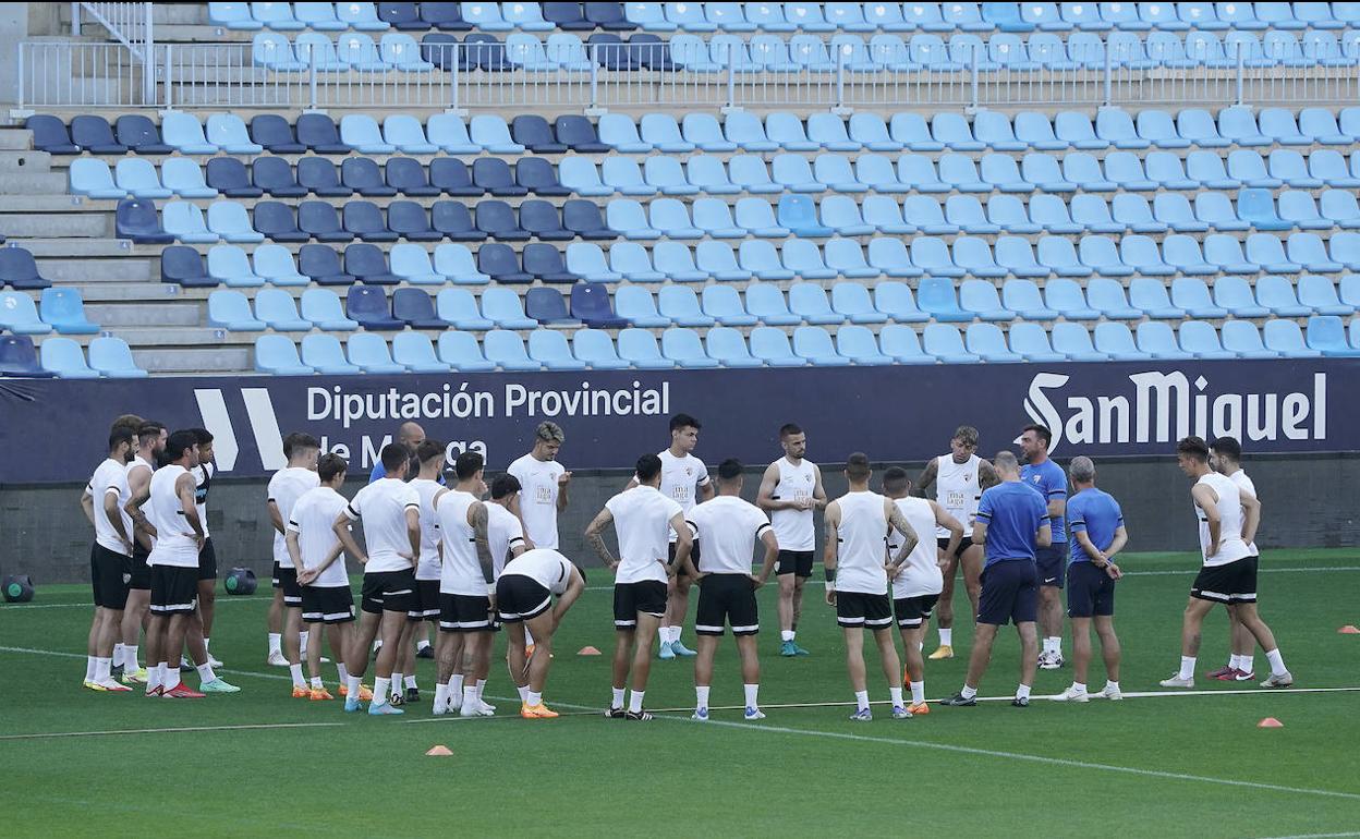 Los jugadores del Málaga atienden las instrucciones de Guede durante el entrenamiento de ayer en La Rosaleda.