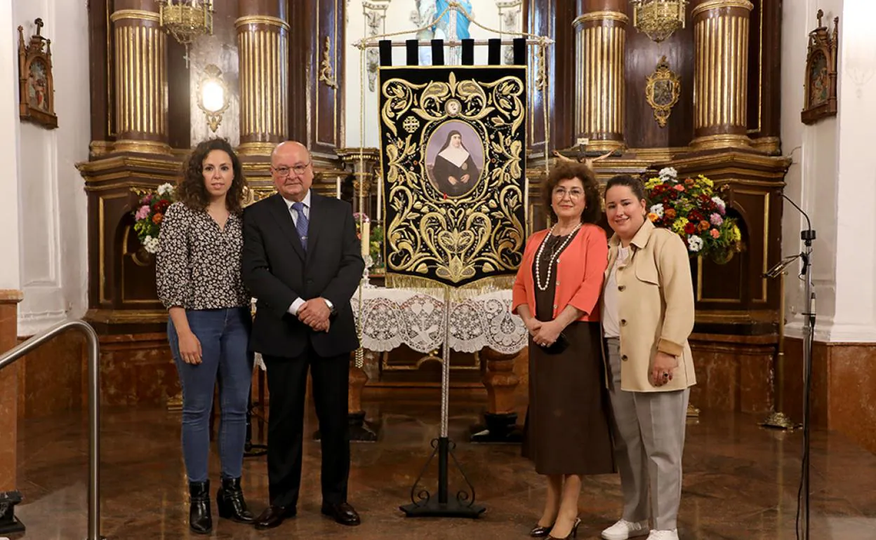 El médico y bordador con su familia ante su último trabajo. 