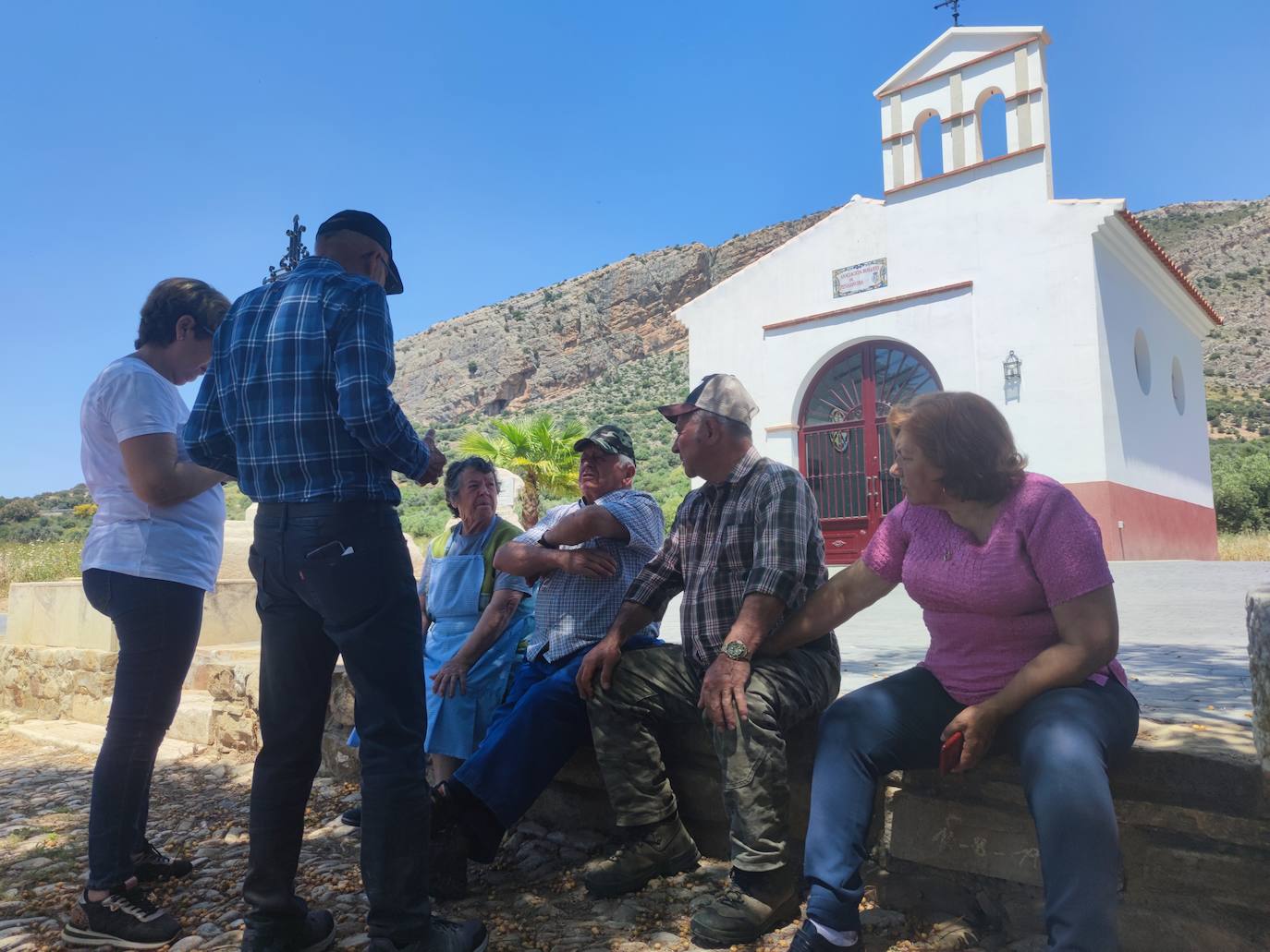 En los primeros meses de 1972 los vecinos se vieron obligados a abandonar su pueblo, que desapareció bajo las aguas del pantano del Guadalteba. En la imagen varios vecinos de Peñarrubia conversan en la puerta de la ermita, junto al pantano.