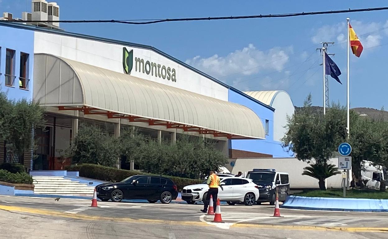 Instalaciones de la firma Frutas Montosa, en Vélez-Málaga, con un furgón policial en la puerta, ayer. 