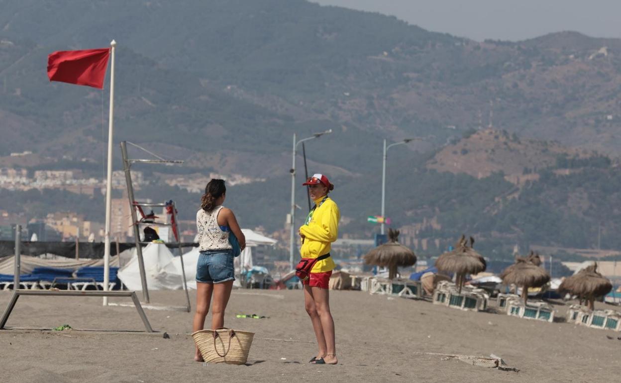 La bandera roja ondea en la playa cerrada. 