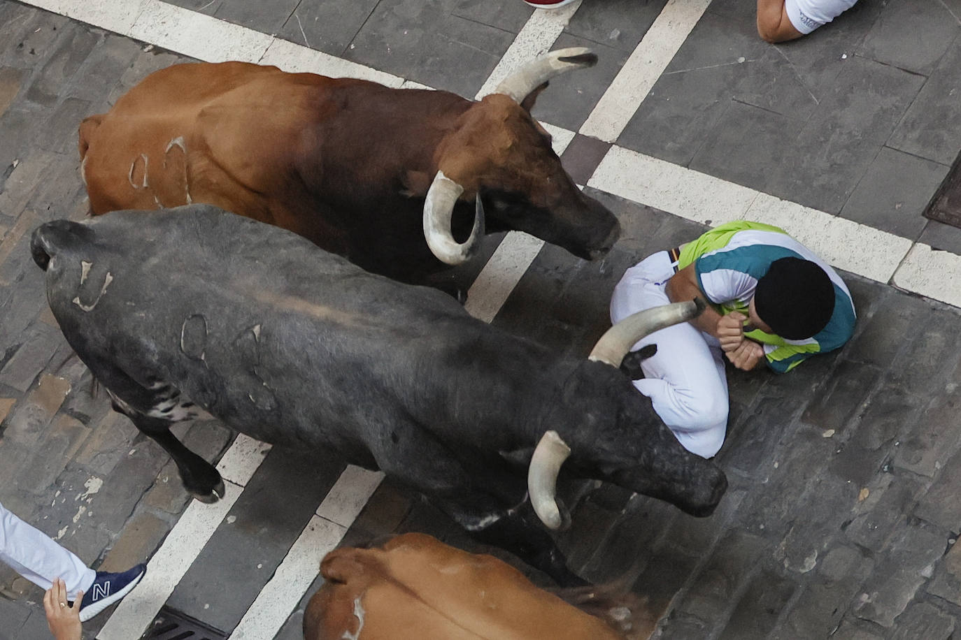 Toros de la ganadería gaditana de Cebada Gago pasa por encima de un mozo a su paso por la calle de la Estafeta.