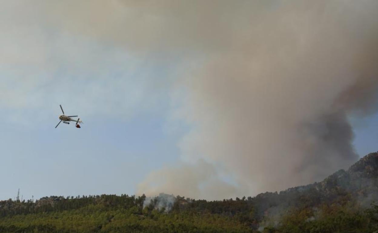 Un helicóptero vierte agua sobre las llamas en las cercanias de Monfrague. 