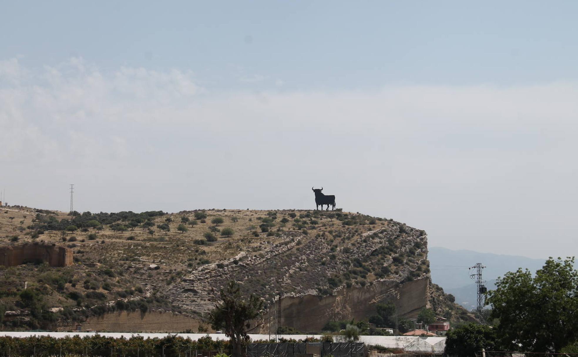 A la izquierda, restos de una antigua cantera, y a la derecha la imagen icónica de Osborne sobre el Peñón del Toro, de Almayate.