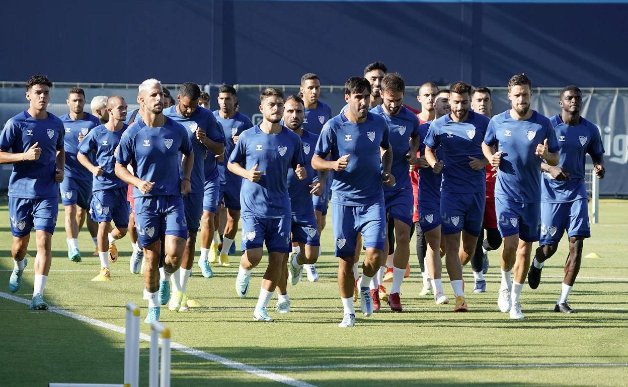 Los jugadores del Málaga realizan carrera continua en el entrenamiento de este lunes en el Anexo de La Rosaleda.