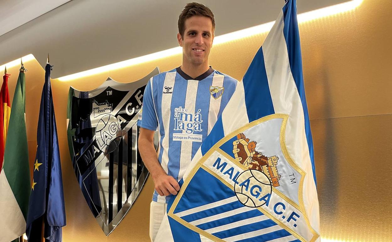 Pablo Hervías, ayer en las oficinas del Málaga, con una bandera del club y tras firmar su contrato. 