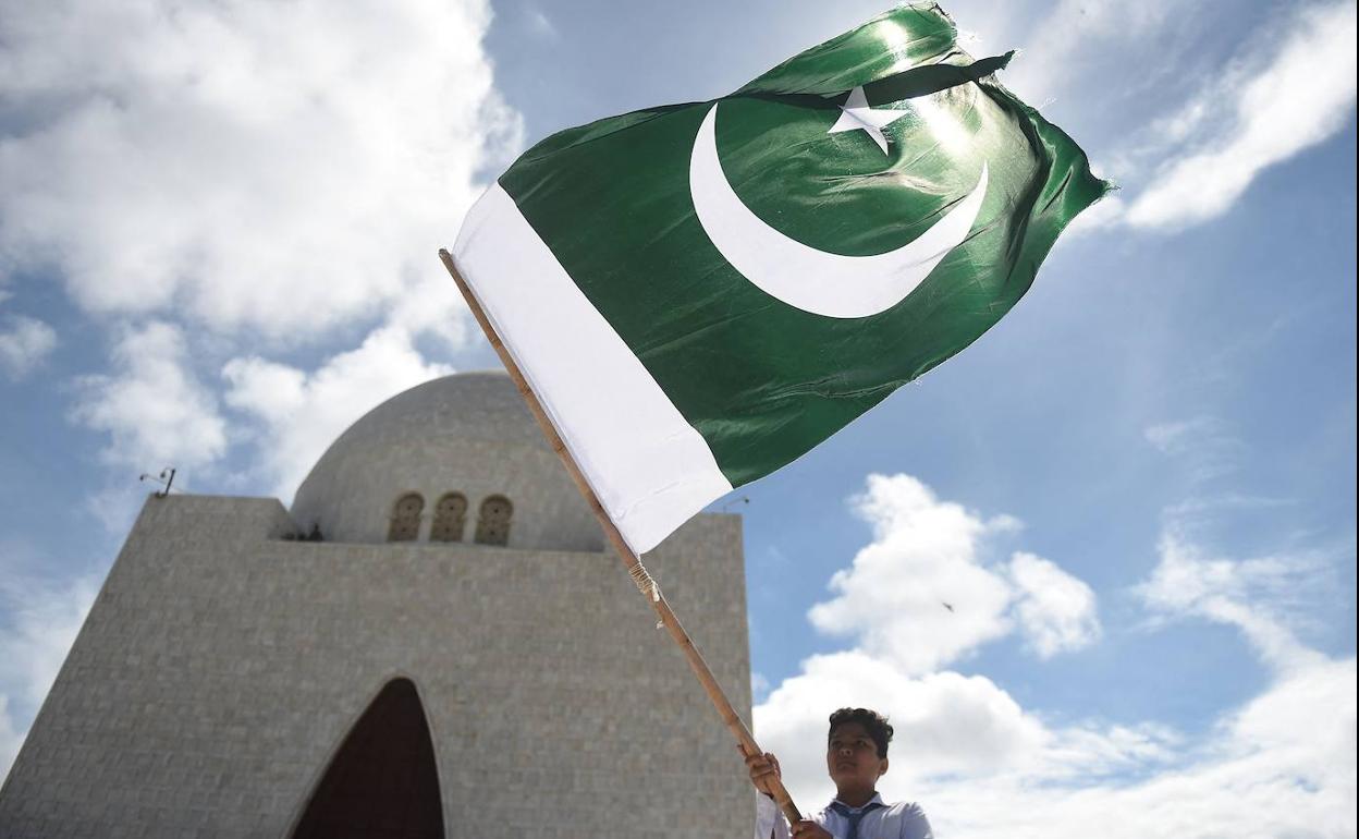 Un estudiante ondea la bandera nacional de Pakistán frente al mausoleo del fundador del país, Mohammad Ali Jinnah, en el 75 aniversario de su independencia.