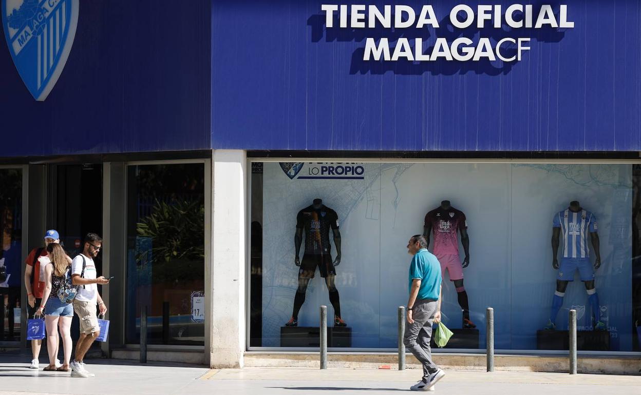 Imagen de la fachada de la tienda del Málaga en La Rosaleda, ayer con varios aficionados saliendo con sus compras.