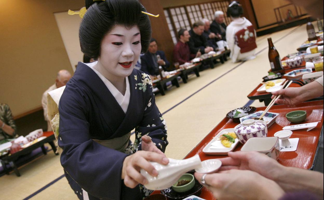 Una mujer sirve sake en un local de Tokio.