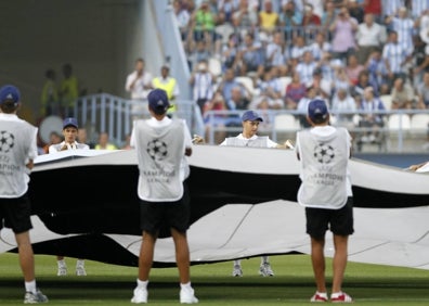 Imagen secundaria 1 - Arriba, la pancarta en Fondo que rezaba 'Lo que no vieron nuestros abuelos lo verán nuestros hijos', a la salida de los equipos; sobre estas líneas, voluntarios agitan una lona con el logo de la Champions, y a la derecha la portada de este diario el día siguiente al partido, tras el 2-0. 