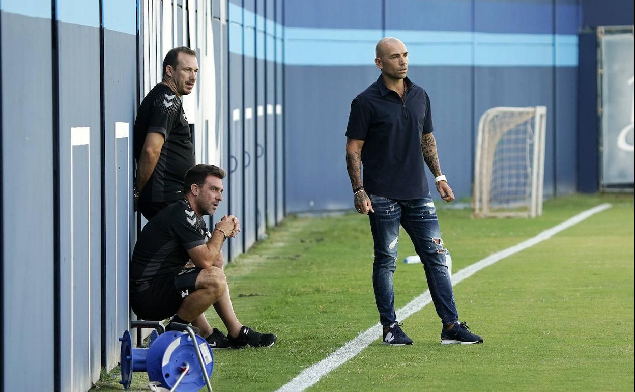 El director deportivo del Málaga, Manolo Gaspar, observa un entrenamiento del equipo junto al entrenador, Pablo Guede (en cuclillas).