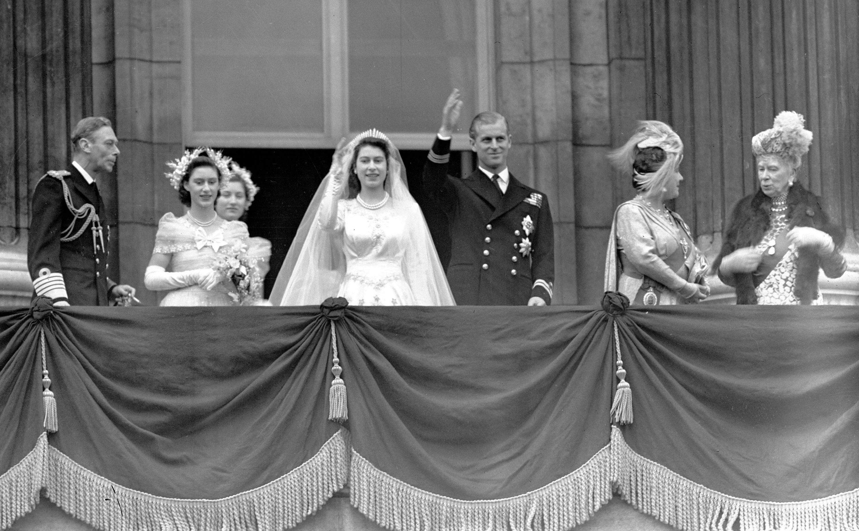 La entonces princesa Isabel y su marido, el príncipe Felipe, duque de Edimburgo, saludan a la multitud desde un balcón del Palacio de Buckingham después de su boda, el 20 de noviembre de 1947. De izquierda a derecha, el rey Jorge VI; la princesa Margarita; Lady Mary Cambridge; la reina Isabel; y la reina María.