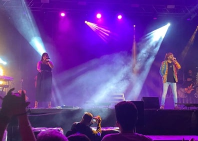 Imagen secundaria 1 - Arriba, imagen de Guaro, iluminado por 20.000 velas. Abajo, El Arrebato cantó con Alicia Jiménez, y durante su actuación. 