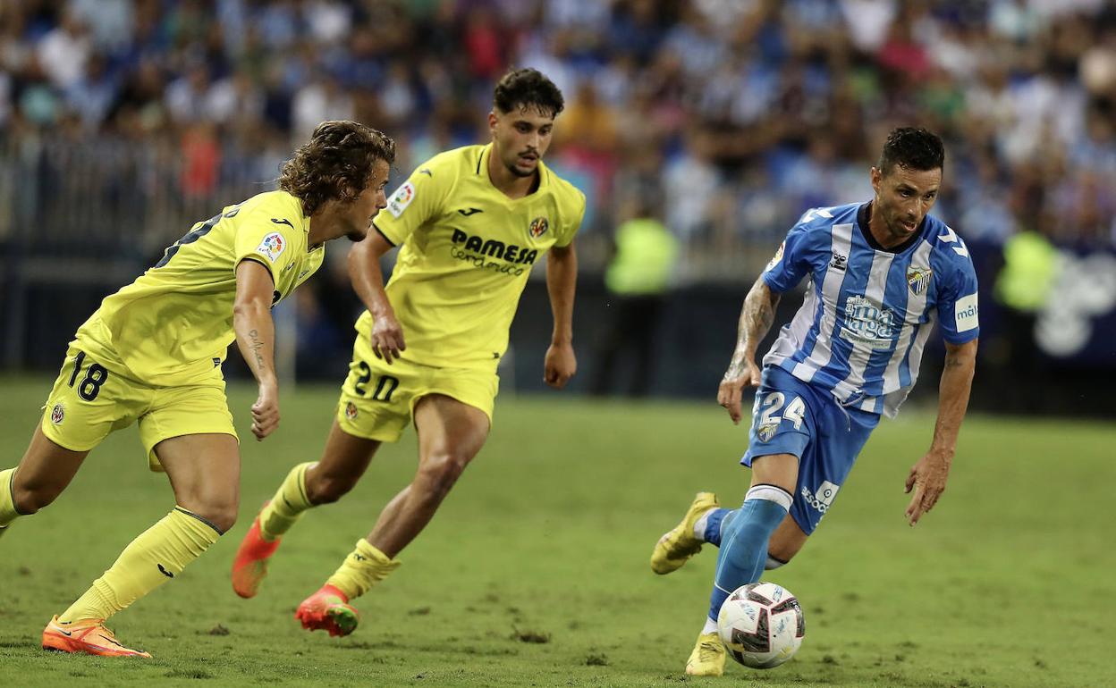 Rubén Castro controla el balón ante la vigilancia de Carlos Romero y Pacheco. 