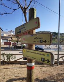 Imagen secundaria 2 - Senderista leyendo un cartel sobre las lagunas de Hondonero. Ermita de Nuestra Señora del Rosario, a un kilómetro del casco urbano. Señalética a la llegada de Villanueva del Rosario.