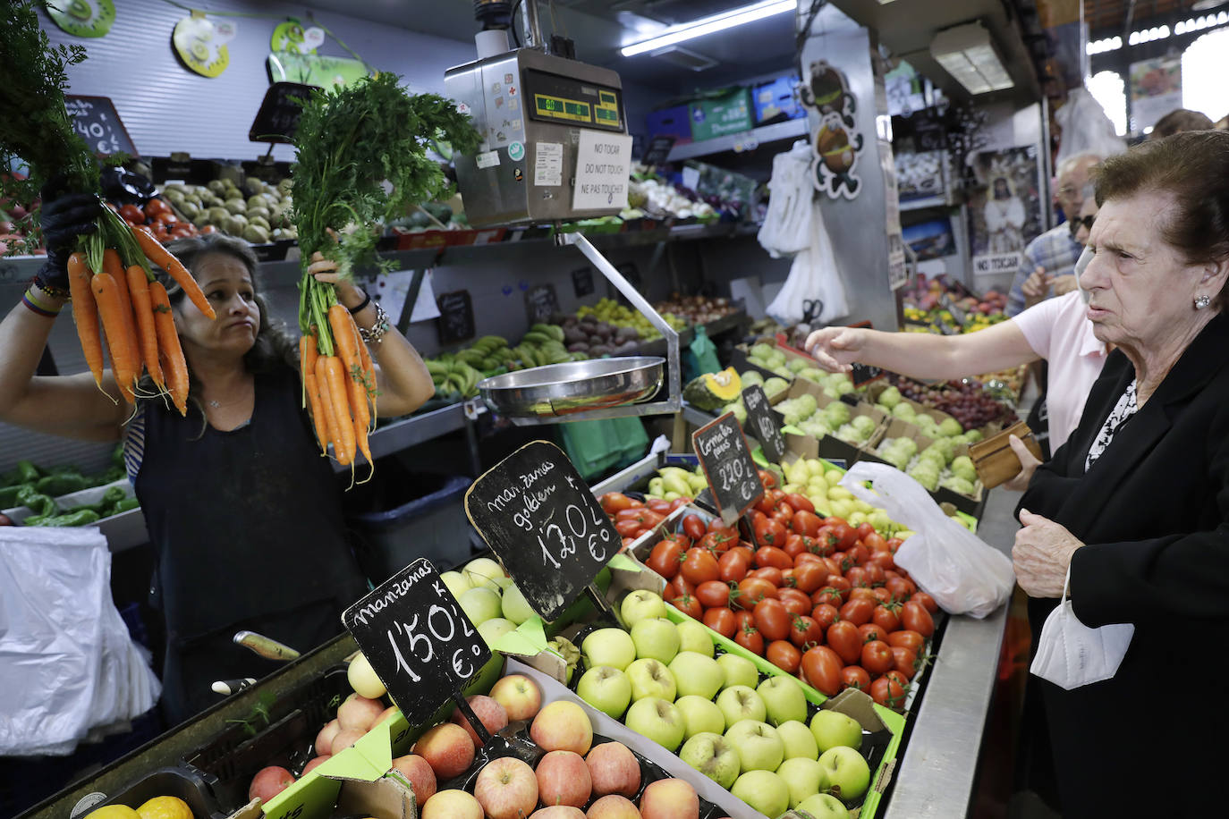 Mujeres compran en uno de los puestos del Mercado de Atarazanas. 