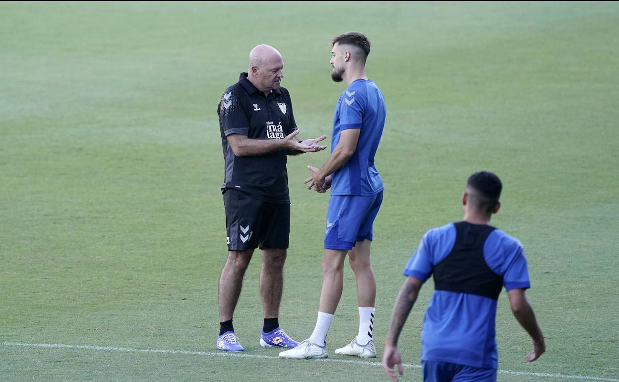 El técnico del Málaga, Pepe Mel, y el jugador, Genaro Rodríguez, conversan durante el comienzo del entrenamiento del equipo este jueves en La Rosaleda.