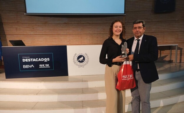 Martina Zgoda recoge el premio de mano del decano de la Facultad de Turismo, Antonio Guevara. 