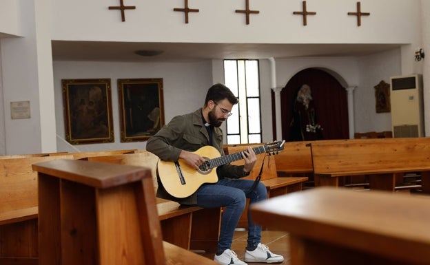 Juan Baena toca la guitarra en uno de los bancos de la parroquia de La Cala de Mijas. 