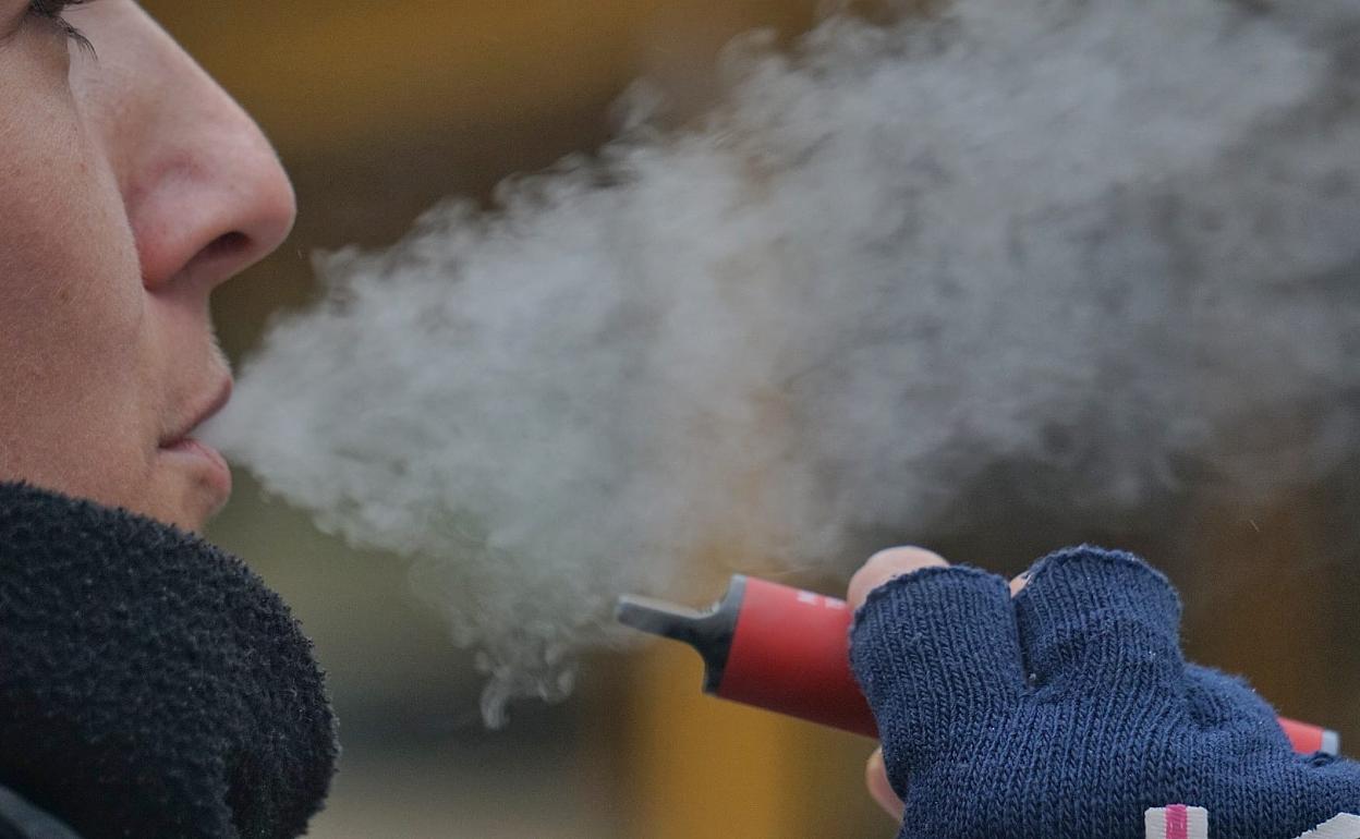 Una joven, con un váper en el exterior de un instituto de la capital. 