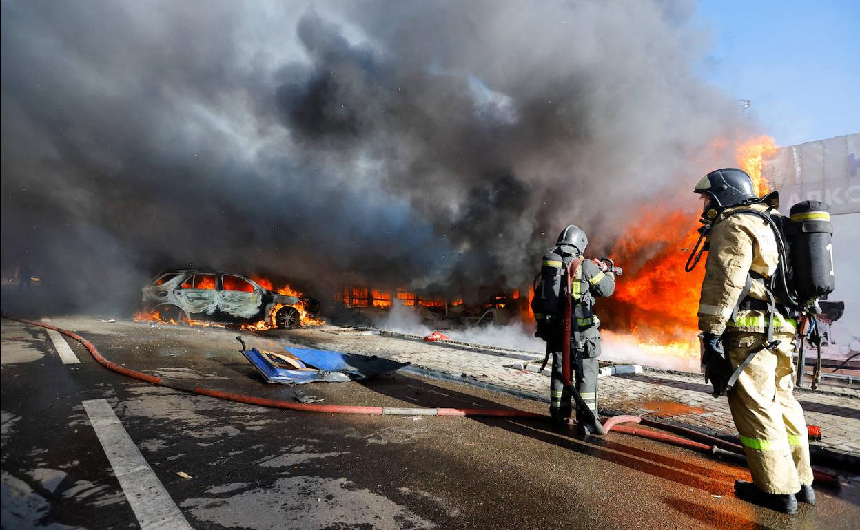 Un bombero trabaja para extinguir el fuego en los puestos del mercado afectados por los bombardeos.