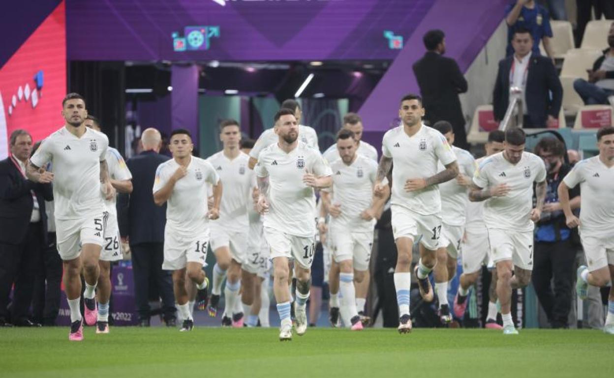 Messi salta al terreno de juego rodeado de sus compañeros de Argentina.