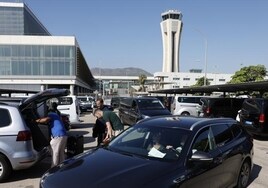 Viajeros del Aeropuerto de Málaga, con la torre de control al fondo.