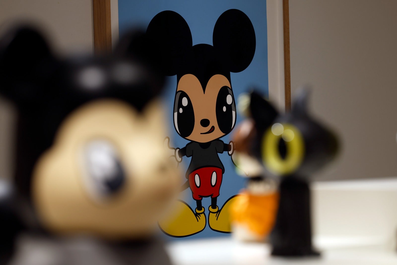 Una versión de Mickey Mouse entre dos 'toy arts' del artista.
