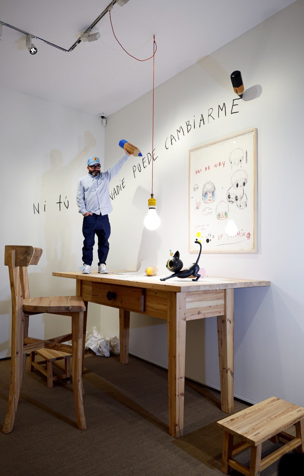 El artista sobre el escritorio gigante que puede verse en la muestra. 