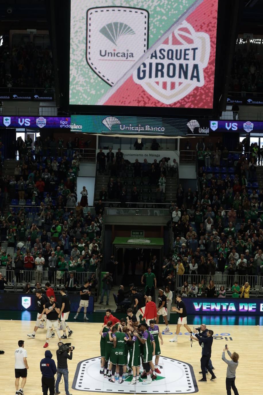 La previa del Unicaja-Girona estuvo marcada por la emoción: hubo fotos con la Copa, documental en el videomarcador e izado de la bandera con el nuevo título del club malagueño