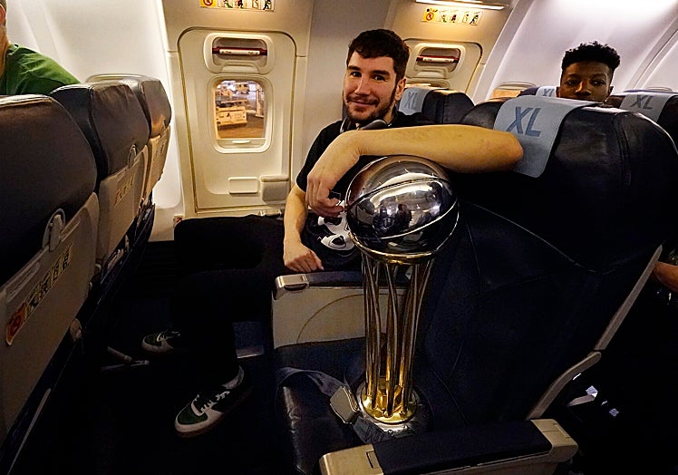 Brizuela, en el avión de vuelta de la Copa sonriente junto al trofeo.