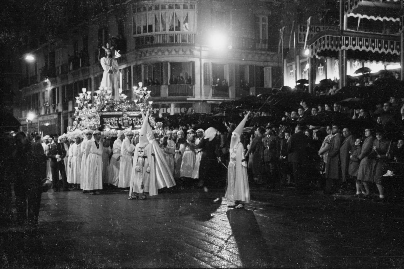 La temida lluvia para los cofrades sorprendió a las hermandades del Lunes Santo en 1946 cuando todas ellas se encontraban en la calle. Pese al contratiempo, la hoy plaza de la Constitución se encontraba repleta de público al paso de Jesús Cautivo, que era portado en un trono realizado por José Fernández Salmerón en 1944.