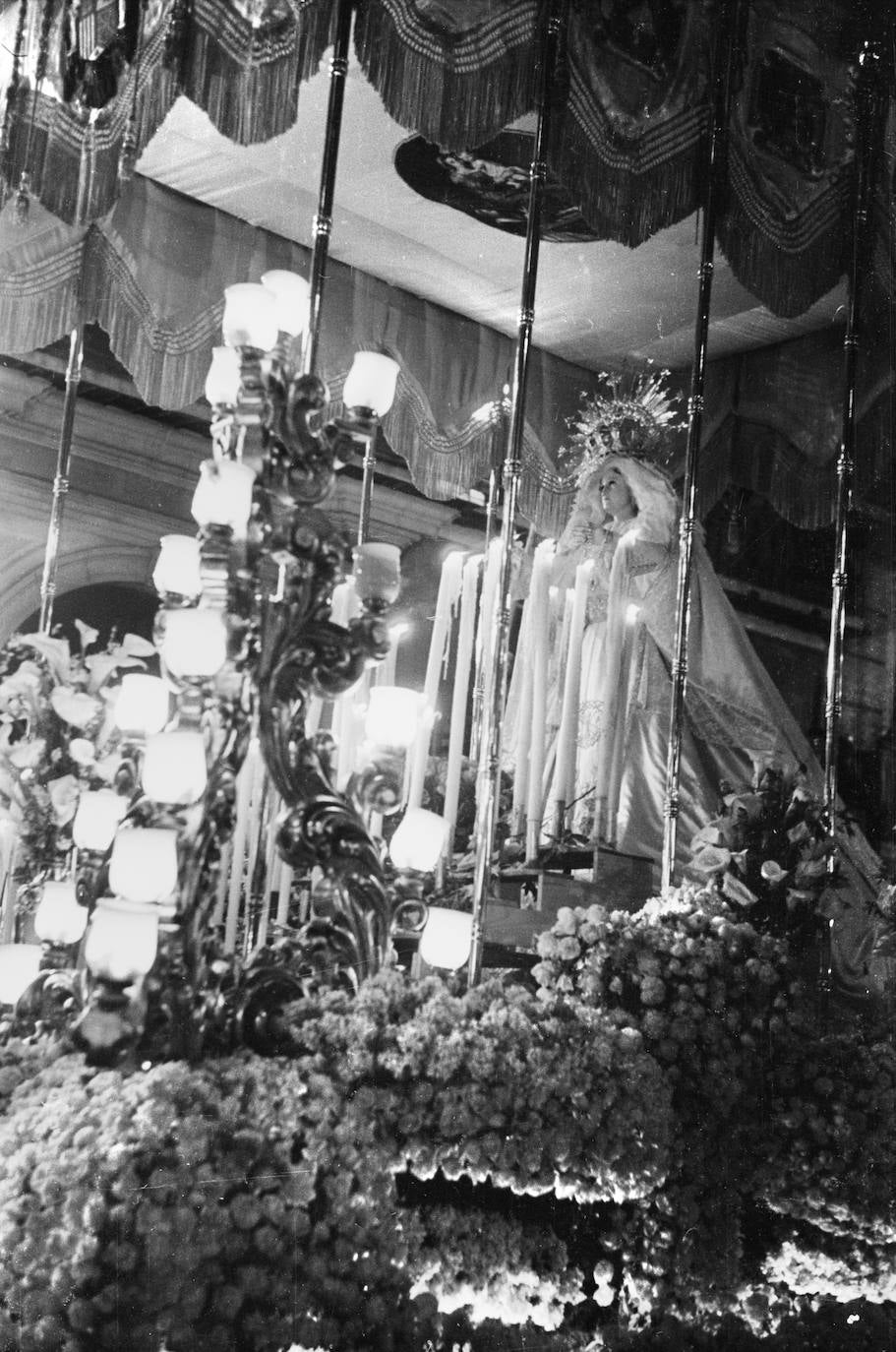 La Virgen del Rosario, en su origen, una Inmaculada Concepción de culto doméstico atribuida a la saga de escultores del siglo XIX, los Gutiérrez de León, poseía un tamaño algo inferior a lo habitual en las tallas de Semana Santa. En la imagen puede observarse lo elevada que se situaba en el trono, en el que hacían de candelería unos escalones de madera para colocar velas. Todo ello se intentaba disimular con un exuberante adorno floral.