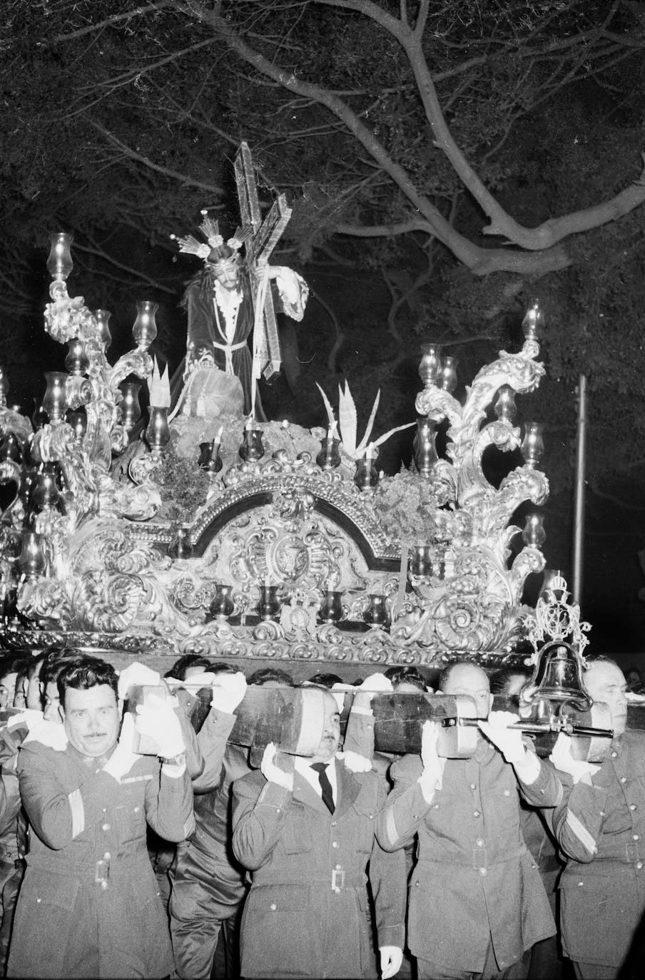 La relación de la Cofradía de la Misericordia con el Ejército del Aire ya era muy estrecha en los años 50 del pasado siglo. Prueba de ello son los miembros de este cuerpo militar que, en la fotografía, hacen las veces de portadores del trono que talló Francisco Palma Burgos.