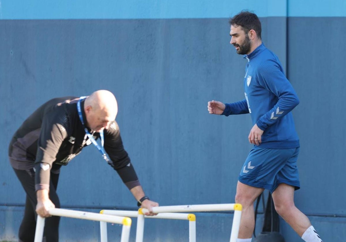 Adrián pasa junto junto a Pepe Mel durante un entrenamiento.