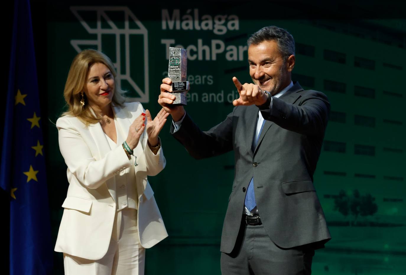 La consejera de Economía, Carolina España, después de entregarle el premio al director general de Opplus, Pablo Benavides. 