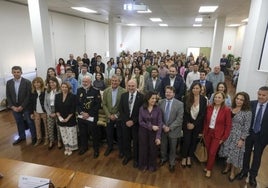 Los estudiantes, tras las autoridades, en el salón de actos de la Facultad de Ciencias Económicas y Empresariales.