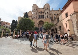 Varios grupos de turistas hacen una parada en la plaza de los Naranjos para inmortalizar la Catedral de Málaga.