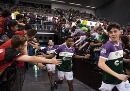Los jugadores del Unicaja saltan a la pista del Palacio de Deportes de Granada el sábado, jaleados por aficionados.