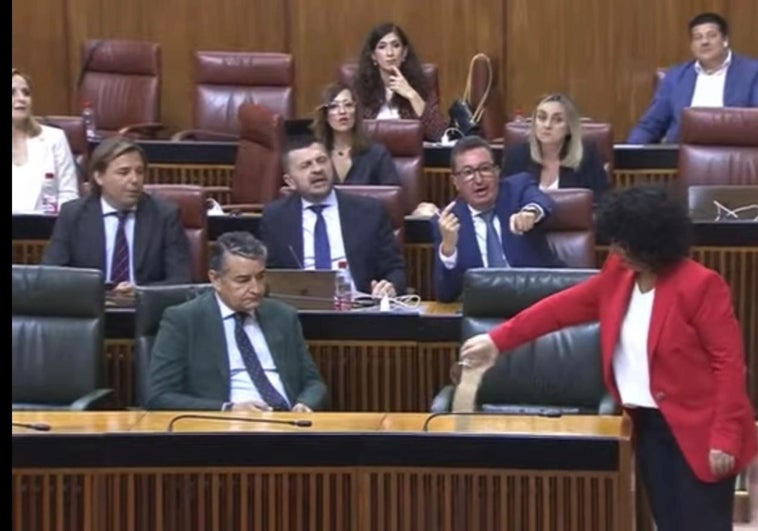 Momento en el que la diputada arroja arena sobre el escaño de Juanma Moreno.