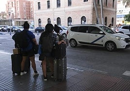 Viajeros en la parada de taxis de la estación de trenes María Zambrano.