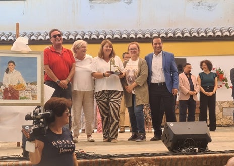 Imagen secundaria 1 - Arriba, la familia Carreira, de Vélez-Málaga, con sus cajas de nísperos; y abajo, dos imágenes de la fiesta en la plaza de Sayalonga.