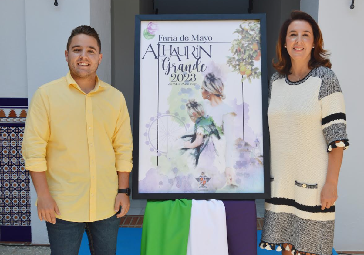 Francisco Burgos y Toñi Ledesma, junto al cartel de la Feria.