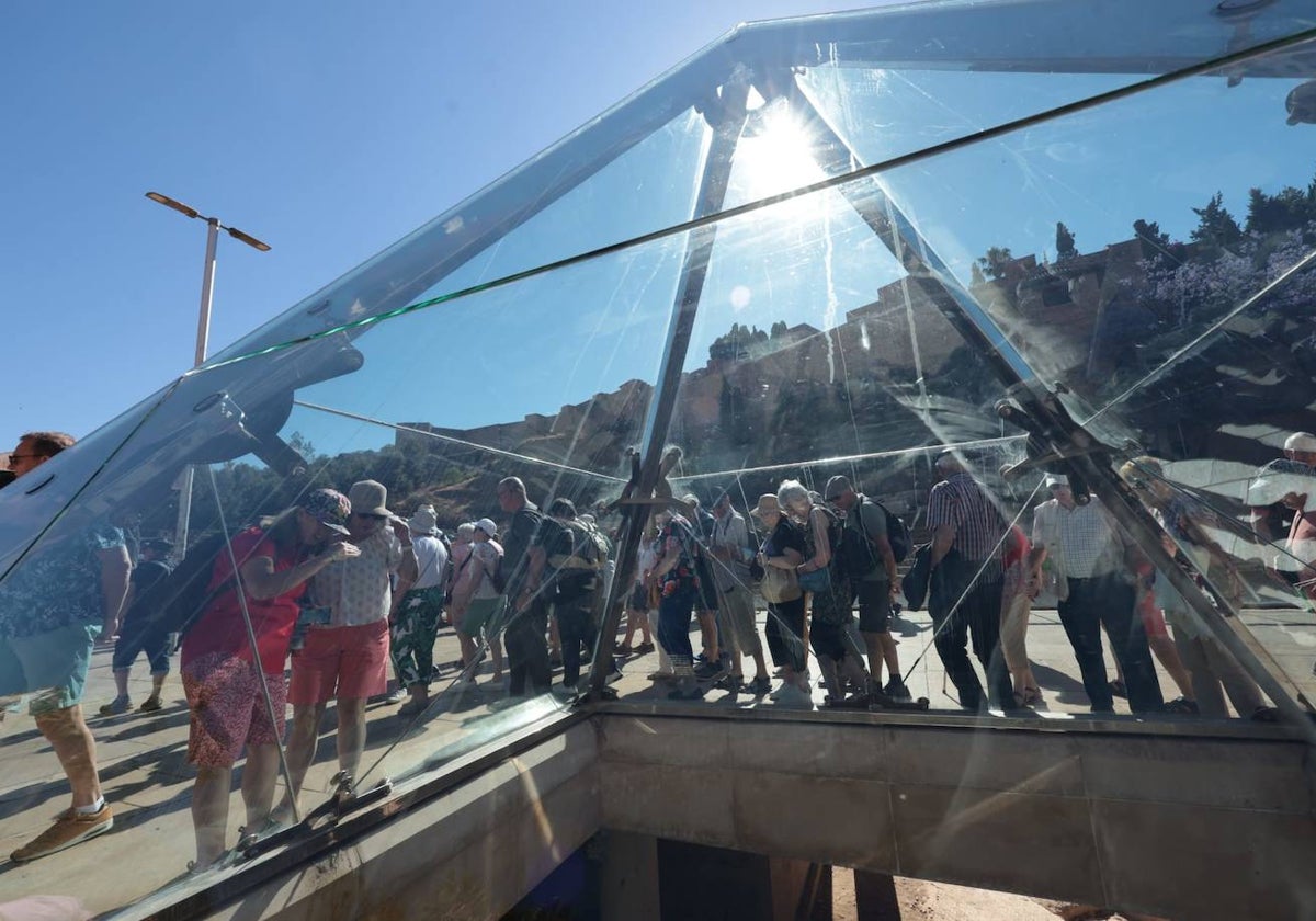 Turistas contemplan los restos romanos de la ciudad de Málaga.