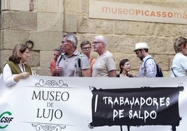 Pancarta de los trabajadores, con visitantes del Museo Picasso detrás, durante la pasada huelga.