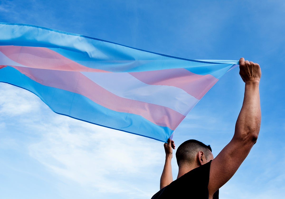 Un joven ondea la bandera trans