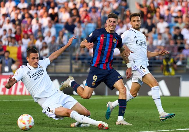 Roberto, entre dos jugadores del Real Madrid Castilla.