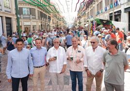 Una comitiva del Málaga visita la feria y posa en la plaza de la Constitución con la calle Larios al fondo.