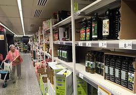 La imagen muestra botellas de aceite de oliva en el lineal de un supermercado de Málaga.